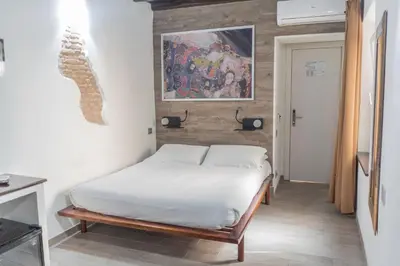 a bedroom with a bed and a painting on the wall at iRooms - Spanish Steps in Rome