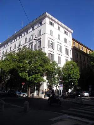 a white building with a person on a motorcycle in front at Hotel Nautilus in Rome