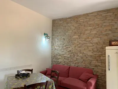 a living room with a red couch and a brick wall at Appia Park apartament 10 min dal Colosseo in Rome