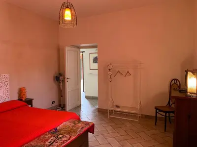 a bedroom with a red bed and a white door at Appia Park apartament 10 min dal Colosseo in Rome