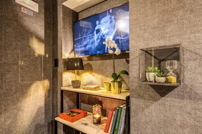 a living room with a tv on a wall at PAX hotel in Rome