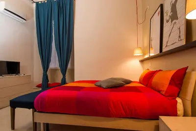 a bedroom with a bed with red and orange at The yellow house in Rome