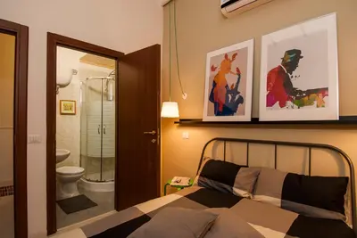 a bedroom with a bed and a bathroom with a toilet at The yellow house in Rome