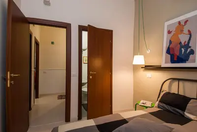 a bedroom with a bed and a door to a hallway at The yellow house in Rome