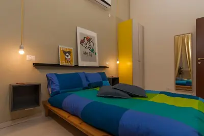 a bedroom with a large bed and a tv at The yellow house in Rome