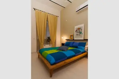 a bedroom with a bed with blue and green sheets at The yellow house in Rome