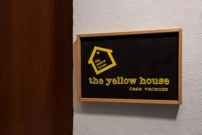 a sign for the yellow house on a wall at The yellow house in Rome