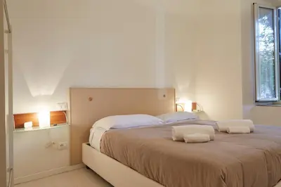 a bedroom with a large bed with two towels on it at Vatican House in Rome