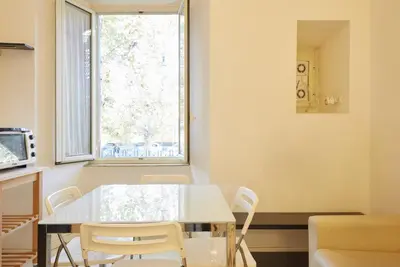 a dining room with a table and chairs and a window at Vatican House in Rome