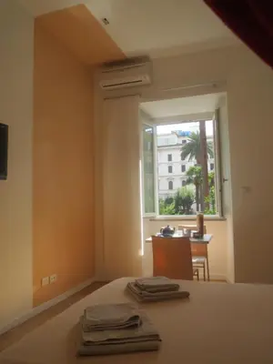 a bedroom with a bed and a window and a table at WellnessINNrome shortlet in Rome