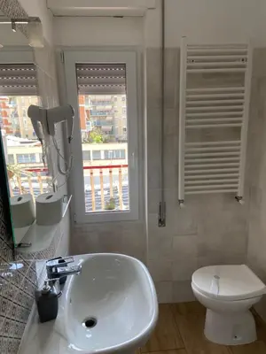 a bathroom with a sink and a toilet and a window at Juna's guest house in Rome