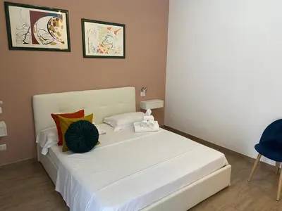 a bedroom with a large white bed with colorful pillows at Juna's guest house in Rome
