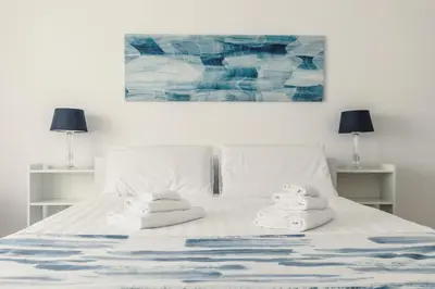a white bed with towels on it with two lamps at Apartment Costanza in Rome in Rome
