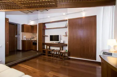 a living room with a table and a desk with a television at Trevi Fountain - Lovely Loft Apartment in Rome