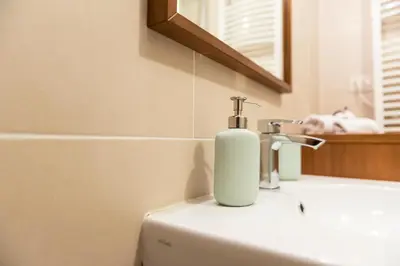 a soap dispenser sitting on top of a bathroom sink at Trevi Fountain - Lovely Loft Apartment in Rome