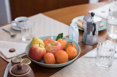 a bowl of apples and oranges on a wooden table at Trevi Fountain - Lovely Loft Apartment in Rome