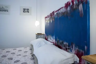 a bedroom with a bed and a painting on the wall at Tempo Lento in Rome