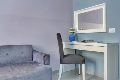 a white bedroom with a bed and a window at Claudia House Roma Termini in Rome