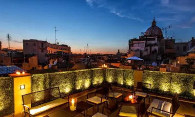 a rooftop patio with lights on a building at Hotel Smeraldo in Rome