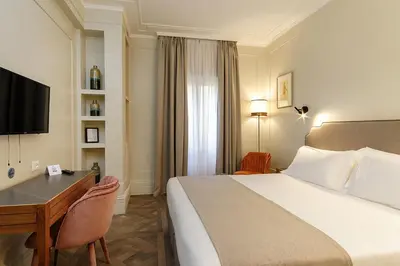 a hotel room with a bed and a desk and a television at Hotel Smeraldo in Rome