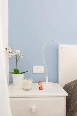 a bedside table with a lamp and flowers on it at The Regal Suite in Rome