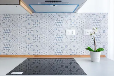 a kitchen with a sink and a tile wall at The Regal Suite in Rome
