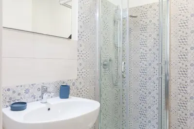 a bathroom with a sink and a glass shower at The Regal Suite in Rome