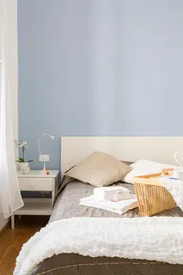 a bedroom with a bed with a white wall at The Regal Suite in Rome