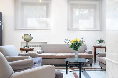 a living room with couches and a table with flowers at Hotel Santa Prisca in Rome
