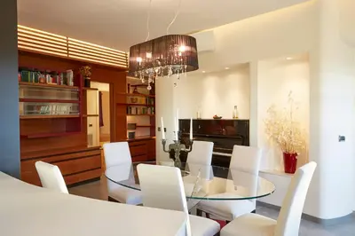 a dining room with a glass table and white chairs at Vatican Luxury Penthouse with Terrace in Rome