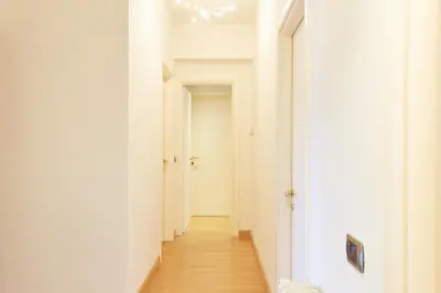 a hallway with white walls and wooden floors at Vatican Luxury Penthouse with Terrace in Rome