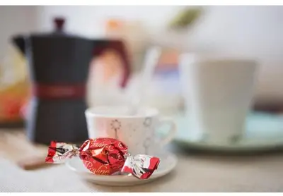 a piece of wrapper on a plate next to a coffee cup at EMI House Re di Roma, Intero Appartamento, 80 mq in Rome