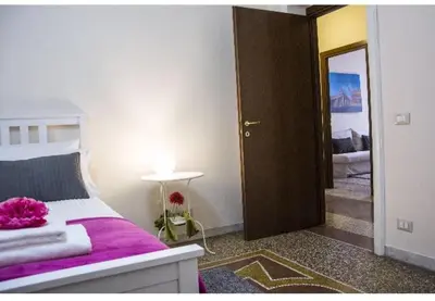 a bedroom with a bed with purple sheets and a mirror at EMI House Re di Roma, Intero Appartamento, 80 mq in Rome
