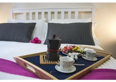 a tray with two cups and a vase on a bed at EMI House Re di Roma, Intero Appartamento, 80 mq in Rome