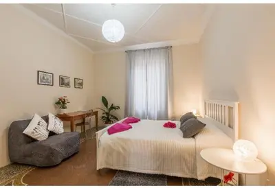 a large white bed with purple sheets and pink flowers on it at EMI House Re di Roma, Intero Appartamento, 80 mq in Rome
