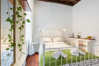a small bedroom with a white bed and a mirror at Enchanting loft in Trastevere in Rome