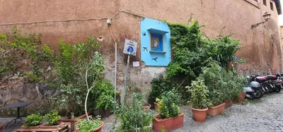 a building with a blue window and plants on it at Enchanting loft in Trastevere in Rome
