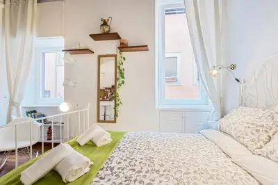 a bedroom with a white bed and a mirror at Enchanting loft in Trastevere in Rome