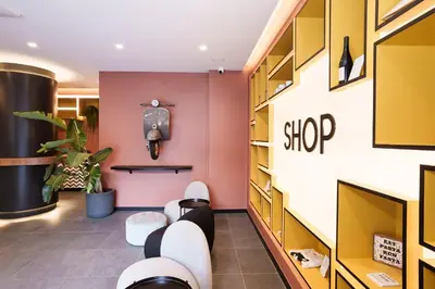 a salon with pink and yellow walls and white chairs at Aparthotel Colombo Roma in Rome