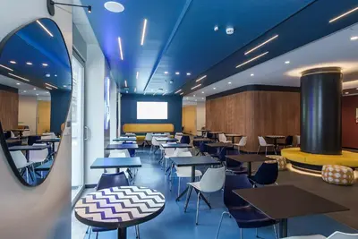 a restaurant with tables and chairs and a screen at Aparthotel Colombo Roma in Rome