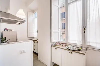 a kitchen with white cabinets and a window at La casa di Nonna Pina in Rome