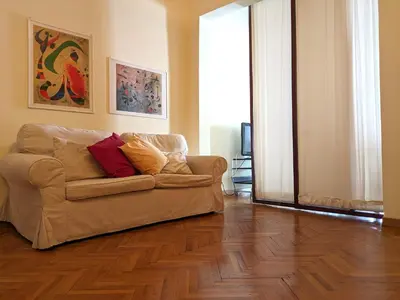 a living room with a couch and wooden floors at Penna Apartment in Rome