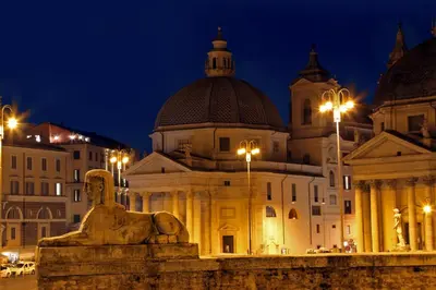 a building with a statue in front of it at night at Penna Apartment in Rome