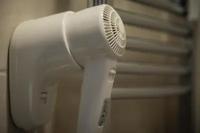 a white hair dryer hanging from a wall at Inside Roma Rooms in Rome