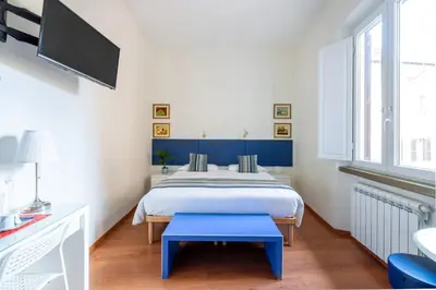 a bedroom with a bed with a blue bench in it at Superior Relais FCollection Temple View in Rome