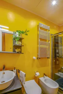 an orange bathroom with a toilet and a sink at Allegra's House Caracciolo in Rome