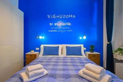 a blue bathroom with a toilet and a shower at Allegra's House Caracciolo in Rome