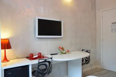 a room with a desk with a television on the wall at Habana's Design in Rome