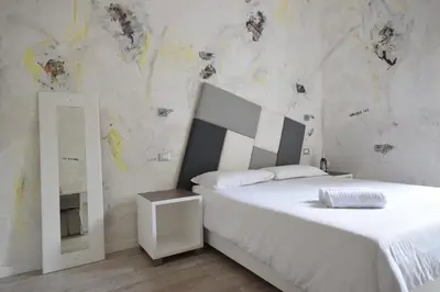 a bedroom with a white bed and a mirror at Habana's Design in Rome