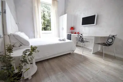 a bedroom with a bed and a desk and a tv at Habana's Design in Rome
